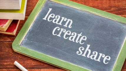 An image of a small blackboard with the words Learn Create and Share in chalk