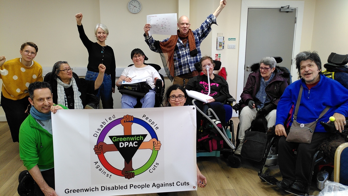 Photo of GDPAC members with their banner, celebrating the session with hands in the air